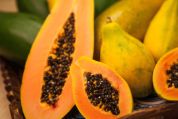 Orange leuchtende, aufgeschnittene Papayas mit schwarzen Kernen Orange leuchtende, aufgeschnittene Papayas mit schwarzen Kernen